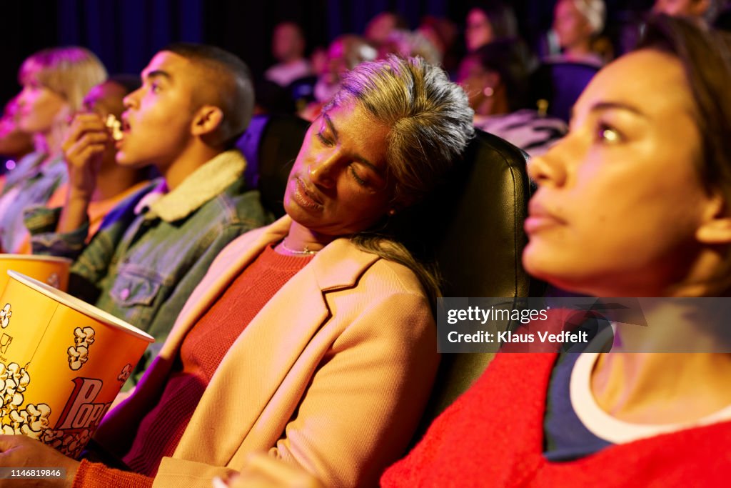 Woman napping while sitting in movie theater