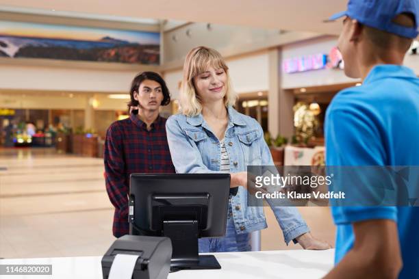 cashier giving ticket to customer at theater - movie counter stock pictures, royalty-free photos & images