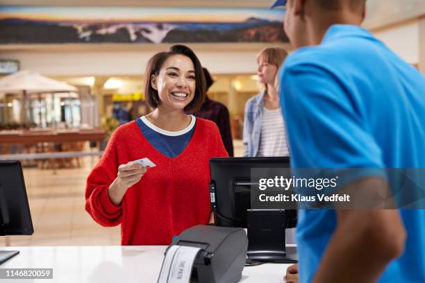 happy customer buying tickets at theater - ticket counter fotografías e imágenes de stock