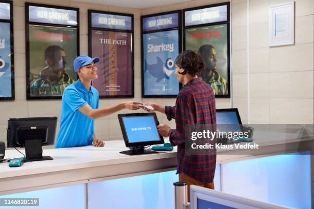 cashier selling movie tickets in theater - movie counter stock pictures, royalty-free photos & images