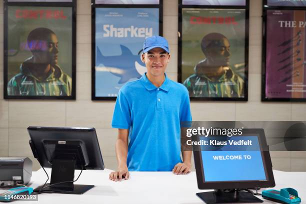 portrait of male cashier at ticket counter - man wearing cap photos et images de collection