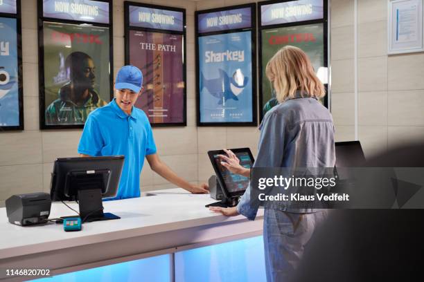 customer using computer at ticket counter - cinema ticket stock pictures, royalty-free photos & images