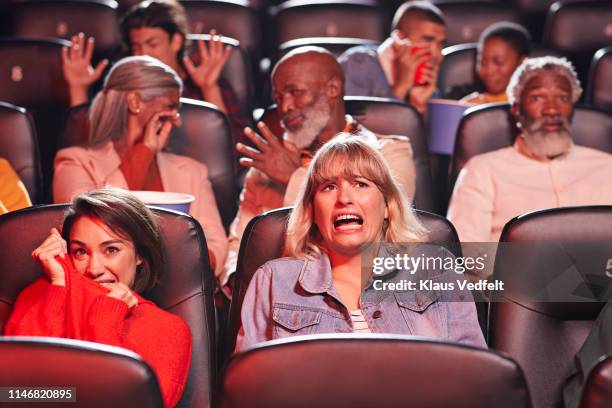 multi-ethnic spectators watching horror movie in cinema hall of theater - horror movie ストックフォトと画像