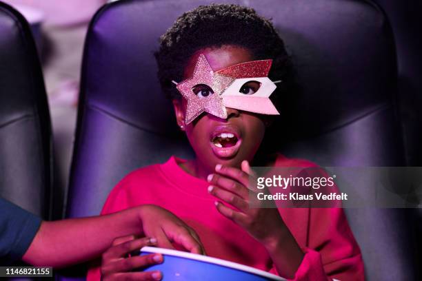 shocked girl eating popcorn while watching movie in theater - human mouth stock photos et images de collection