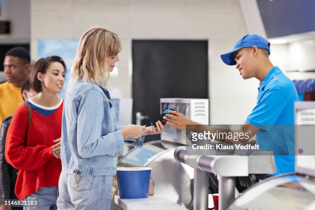 woman paying for snacks at concession stand - movie counter stock pictures, royalty-free photos & images