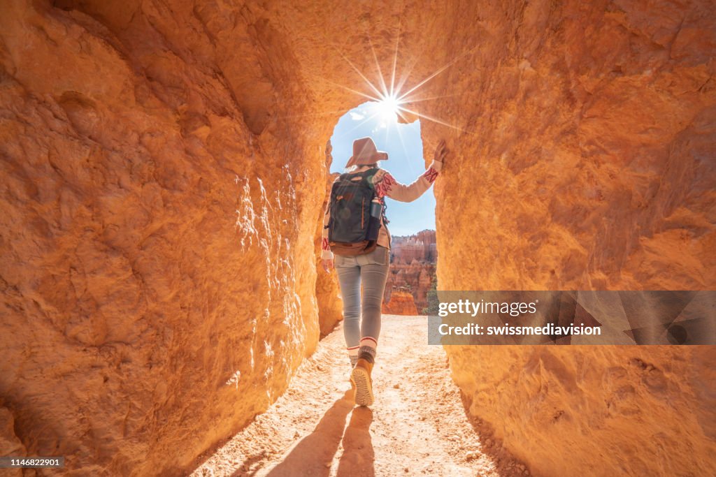 Young woman travels Bryce Canyon national park in Utah, United States, people travel explore nature. Girl hiking in red rock formations