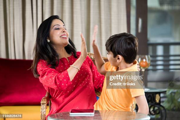 mother giving high five to son - indian mother and child stock pictures, royalty-free photos & images
