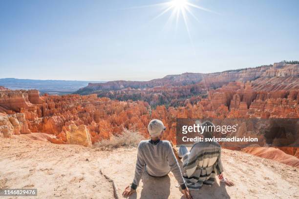 young couple contemplating nature enjoying travel and adventure - america - rock hoodoo stock pictures, royalty-free photos & images
