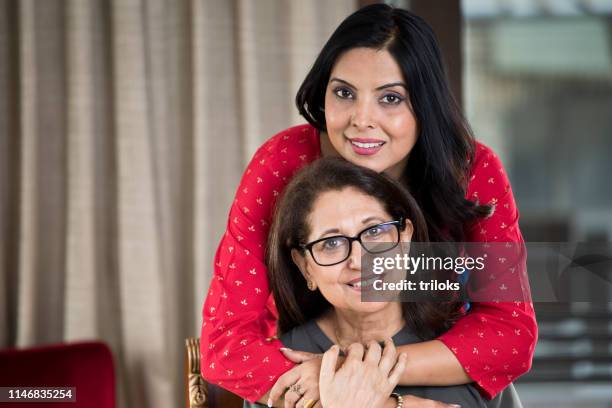 vrouw omarmen senior moeder van achter - indian mother stockfoto's en -beelden