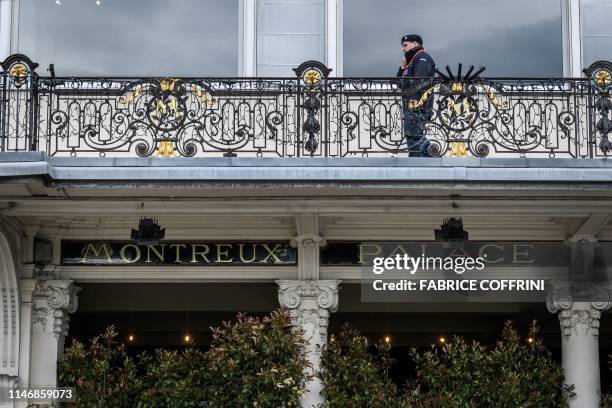 Private secury guard is seen above the entrance of The Fairmont Le Montreux Palace hotel in Montreux on May 29 which is scheduled to host the annual...