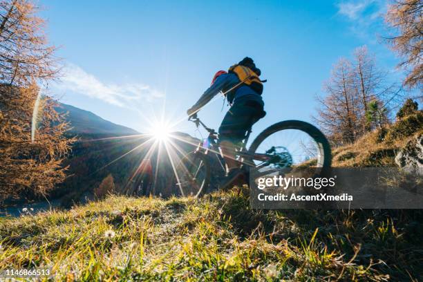 o motociclista da montanha monta abaixo da inclinação gramíneo - livigno - fotografias e filmes do acervo