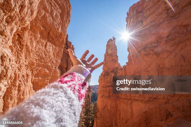 de hand strekt zich uit naar zonlicht van binnenuit red rock canyon, travel concept - rock hoodoo stockfoto's en -beelden