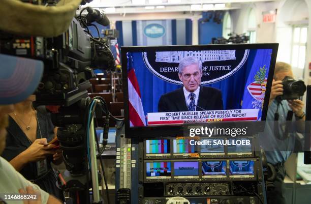 Television screen shows Special Counsel Robert Mueller as he gives a statement at the Department of Justice, as seen from the Brady Press Briefing...