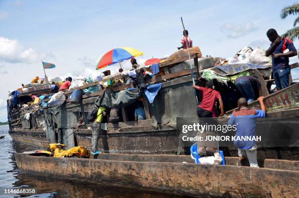Passengers and merchants embark on a barge on the Congo river, in Mbandaka, in northern DR Congo on September 9, 2018. - On May 25 45 people died in...