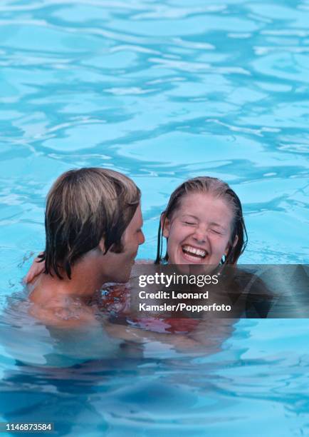 American golfer Ben Crenshaw goofing around with his wife Polly in a swimming pool, circa 1976.