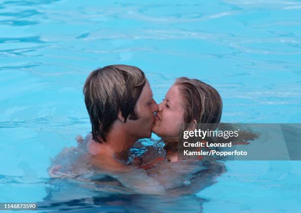 American golfer Ben Crenshaw kissing his wife Polly in a swimming pool, circa 1976.