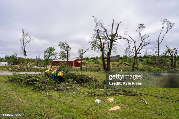 Electrical workers clear power lines from trees after a tornado knocked down a large number of power lines the night before on May 29, 2019 in...