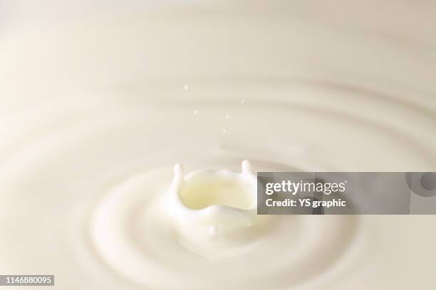 fresh milk single drop splashing in a milk pool. white background. with circle ripples. - goutte lait photos et images de collection