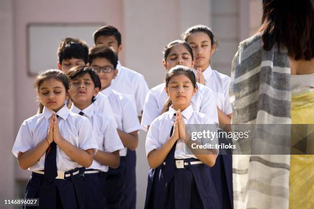 teacher with students praying in school campus - assembly room stock pictures, royalty-free photos & images