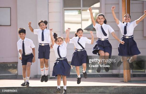 school children jumping and celebrating in school campus - group of happy students jumping up in the air stock pictures, royalty-free photos & images