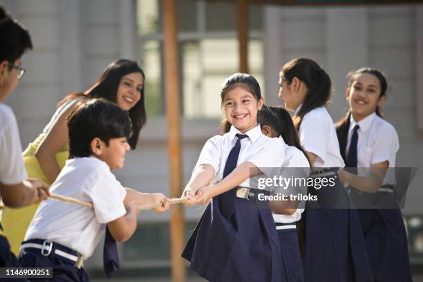 teacher cheering student playing tug of war - 12 year old indian girl stock pictures, royalty-free photos & images