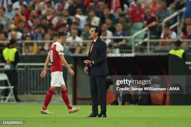 Arsenal manager \ Head coach Unai Emery looks on as the subsituted Mesut Ozil of Arsenal walks by during the UEFA Europa League Final between Chelsea...
