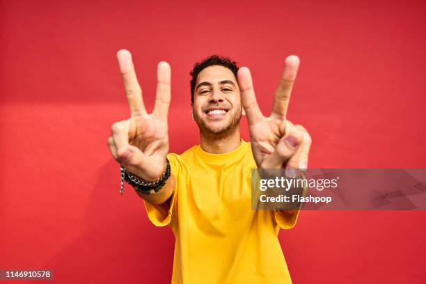 colourful studio portrait of a young man - portrait fond rouge photos et images de collection