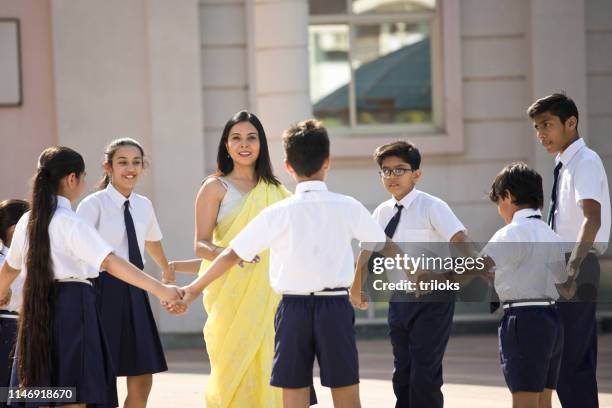 teacher playing with students in campus - all india students association stock pictures, royalty-free photos & images
