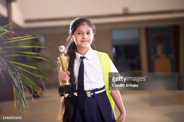 bambina in possesso di trofeo nel campus scolastico - ragazza scuola foto e immagini stock