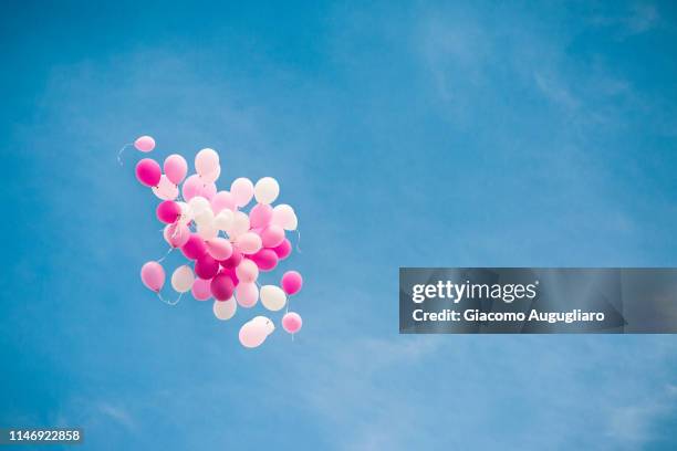 cluster of pink baloons for a girl baptism in the blue sky. italy - event planning stock pictures, royalty-free photos & images