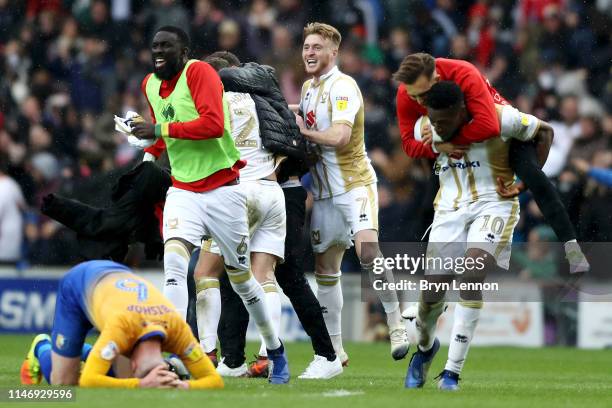 Milton Keynes Dons players celebrate as their team are promoted after the Sky Bet League Two match between Milton Keynes Dons and Mansfield Town at...