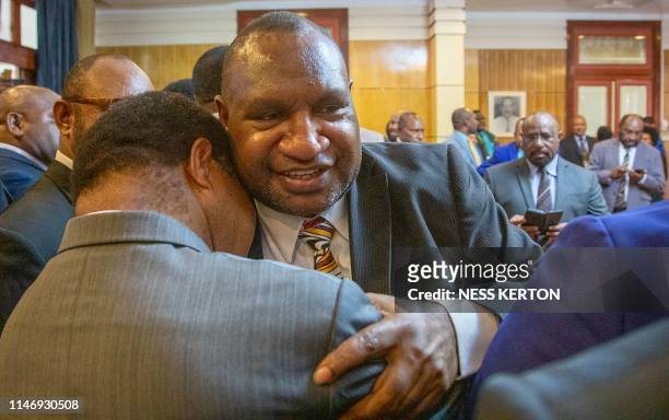 James Marape is hugged by a supporter after being sworn in as the new Prime Minister of Papua New Guinea by Governor General Bob Dadae in Port...