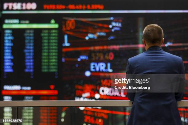 An employee views a FTSE share index board in the atrium of the London Stock Exchange Group Plc's offices in London, U.K., on Wednesday, May 29,...