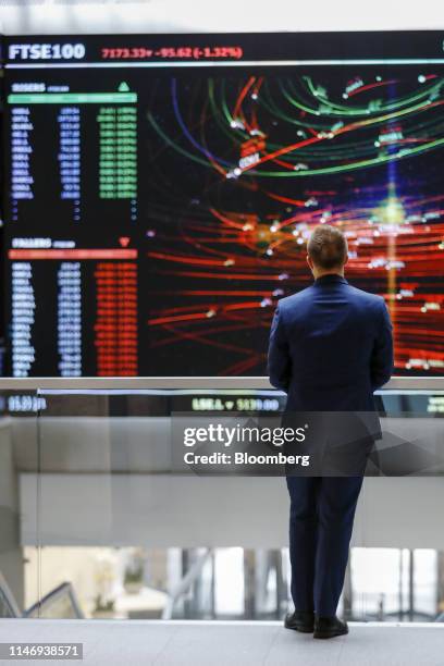 An employee views a FTSE share index board in the atrium of the London Stock Exchange Group Plc's offices in London, U.K., on Wednesday, May 29,...