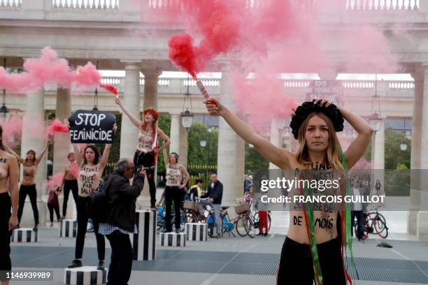 Leader of the feminist activist group Femen Inna Shevchenko brandishes a flare during a protest against feminicide at the Palais Royal in Paris on...