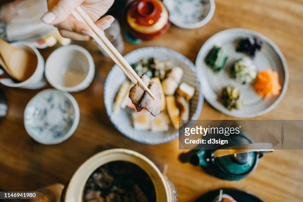 overhead view of woman enjoying delicate japanese cuisine with various side dishes and green tea in the restaurant - fukuoka prefecture stock pictures, royalty-free photos & images