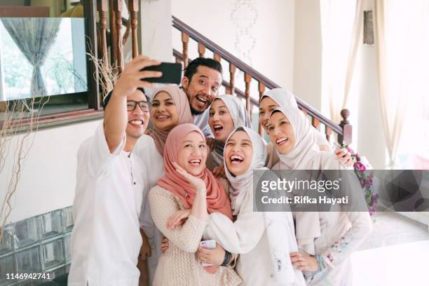 family taking selfie together celebrating hari raya aidilfitri (eid al-fitr) - ramadan eid stock pictures, royalty-free photos & images