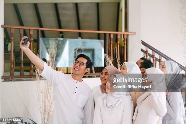 family links selfie together celebrating hari raya aidilfitri (eid al-fitr) - hari raya celebration stock-fotos und bilder