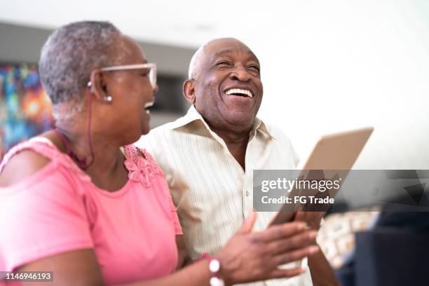 senior couple using digital tablet - children interacting with tablet technology stock pictures, royalty-free photos & images