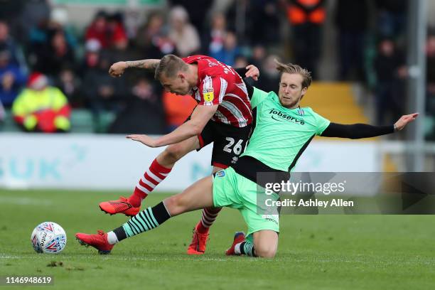 Harry Anderson of Lincoln City is tackled by Ben Stevenson of Colchester United during the Sky Bet League Two match between Lincoln City and...