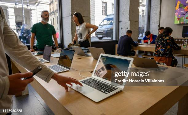 Visitors are briefed about MacBook Air computers on display in the Apple Store at Puerta del Sol square on May 04, 2019 in Madrid, Spain. Apple...