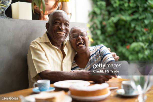 portrait of a happy african senior couple having breakfast - senior men coffee stock pictures, royalty-free photos & images