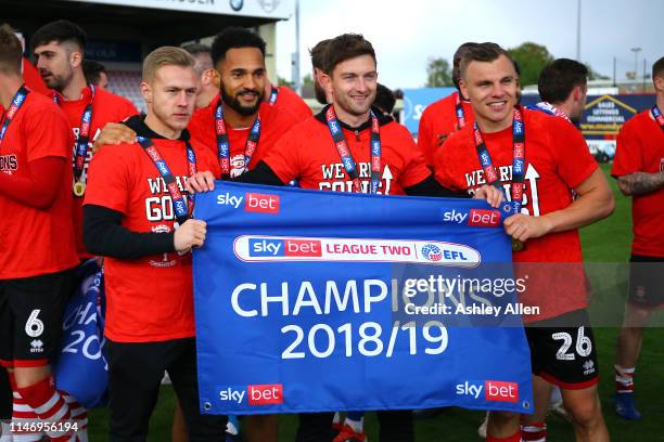 Lincoln City players pose with the Championship banner during the Sky Bet League Two match between Lincoln City and Colchester United at Sincil Bank...