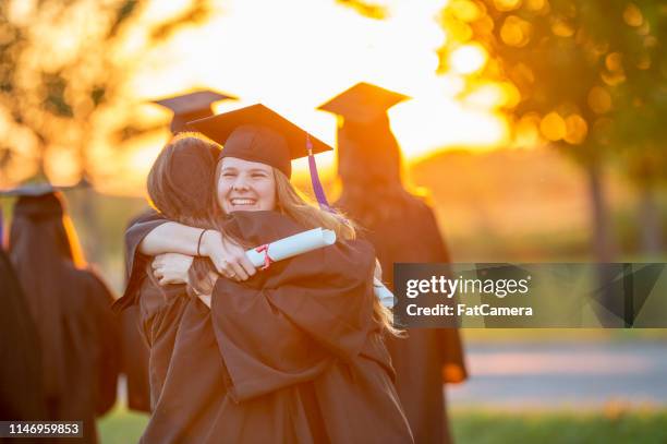 zwei frauen umarmen bei einer abschlussfeier - high school graduation stock-fotos und bilder