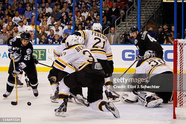 Martin St. Louis of the Tampa Bay Lightning shoots a second period goal past Patrice Bergeron, Johnny Boychuk, Andrew Ference and Tim Thomas of the...
