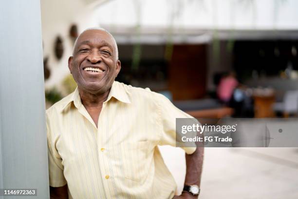 portrait of african senior man with hand on hip - old man afro stock pictures, royalty-free photos & images