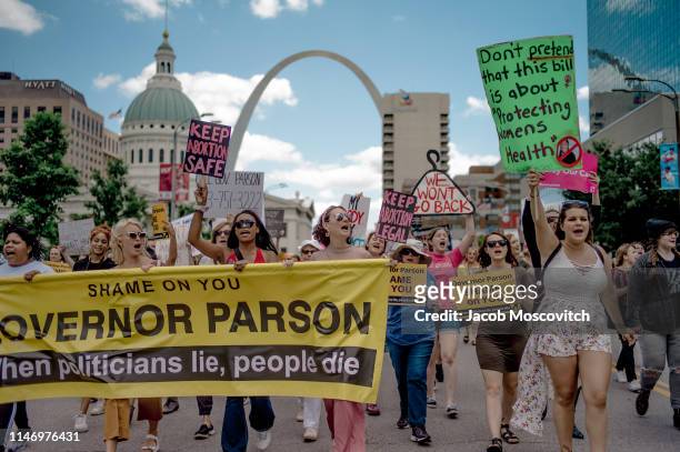 Attendees chant and march through downtown St. Louis during a rally and march to protest the closure of the last abortion clinic in Missouri on May...