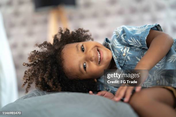 happy young boy playing in the bedroom - a boy jumping on a bed stock pictures, royalty-free photos & images