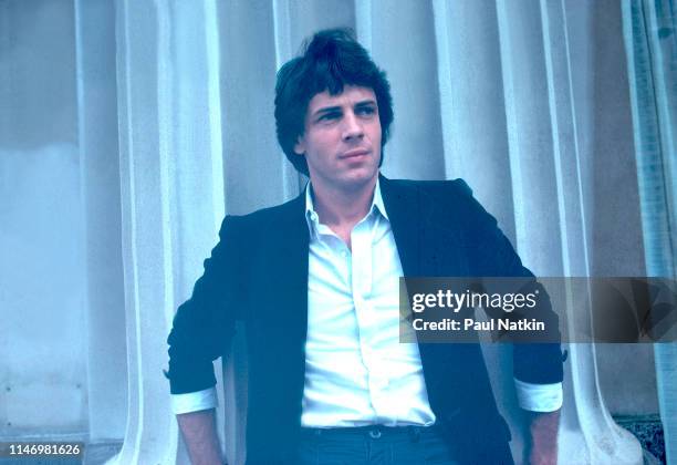 Portrait of American Rock musician Rick Springfield as he poses outdoors, leaning against a fluted column, Chicago, Illinois, July 31, 1981.