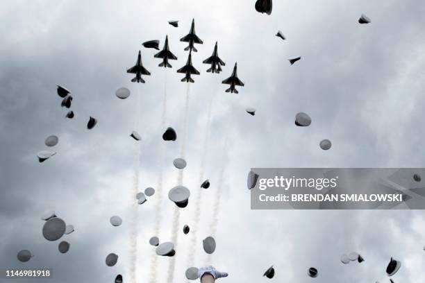 Graduates celebrate and throw up their caps as the Air Force Thunderbirds fly overhead during the 2019 graduation ceremony at the United States Air...